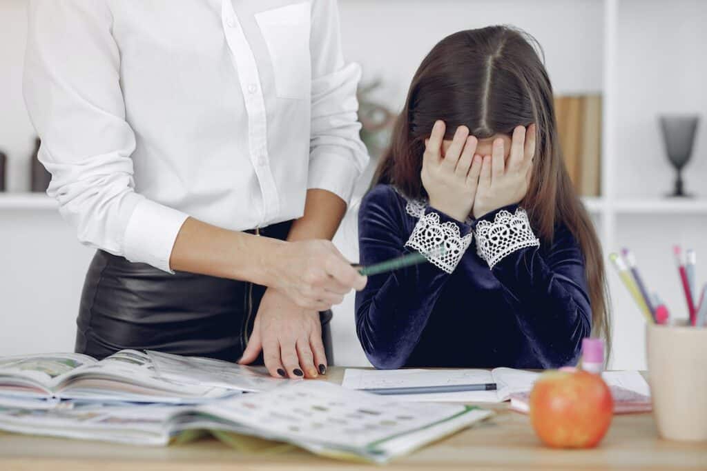 parenting mistakes - mother scolding her daughter while doing homework together