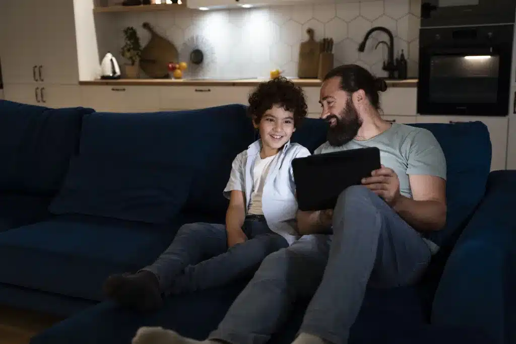 Should parents limit screen time? Child and dad spending time together watching something on the tablet